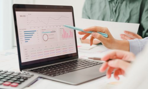 Closeup group of Asian business people meeting discuss project plan and financial results in office. Marketing strategy analysis, stock market trading, financial consultant concept.